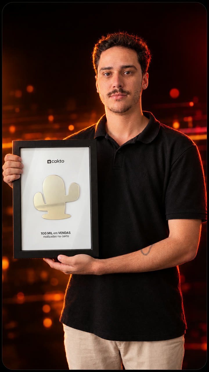 Erik Raphael segurando a placa de 100 mil em vendas da Cakto